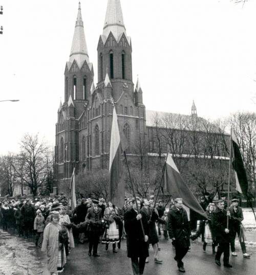 Pirmoji XX a. pabaigos anykštėnų Vasario 16-osios eisena 1989 m. Ją veda vienas iš Lietuvos Atgimimo šauklių anykštėnas Eligijus Smetona (centre tarp vėliavų). A. Baranausko ir A. Vienuolio-Žukausko memorialinio muziejaus fondų nuotrauka.