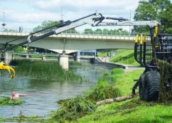 Prie vyskupo Antano Baranausko tilto išpjautas iš Šventosios žoles semia rimta technika, tačiau be žmogaus rankų hidrodarbuotojai išsiversti vis tiek negali.